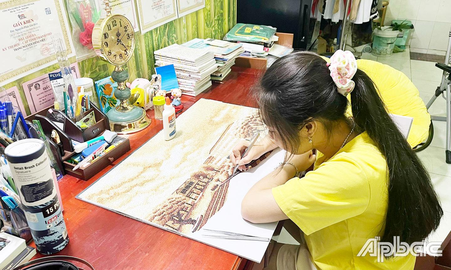Gia Hân tỉ mỉ đến từng chi tiết để thực hiện bức tranh gạo của mình.
